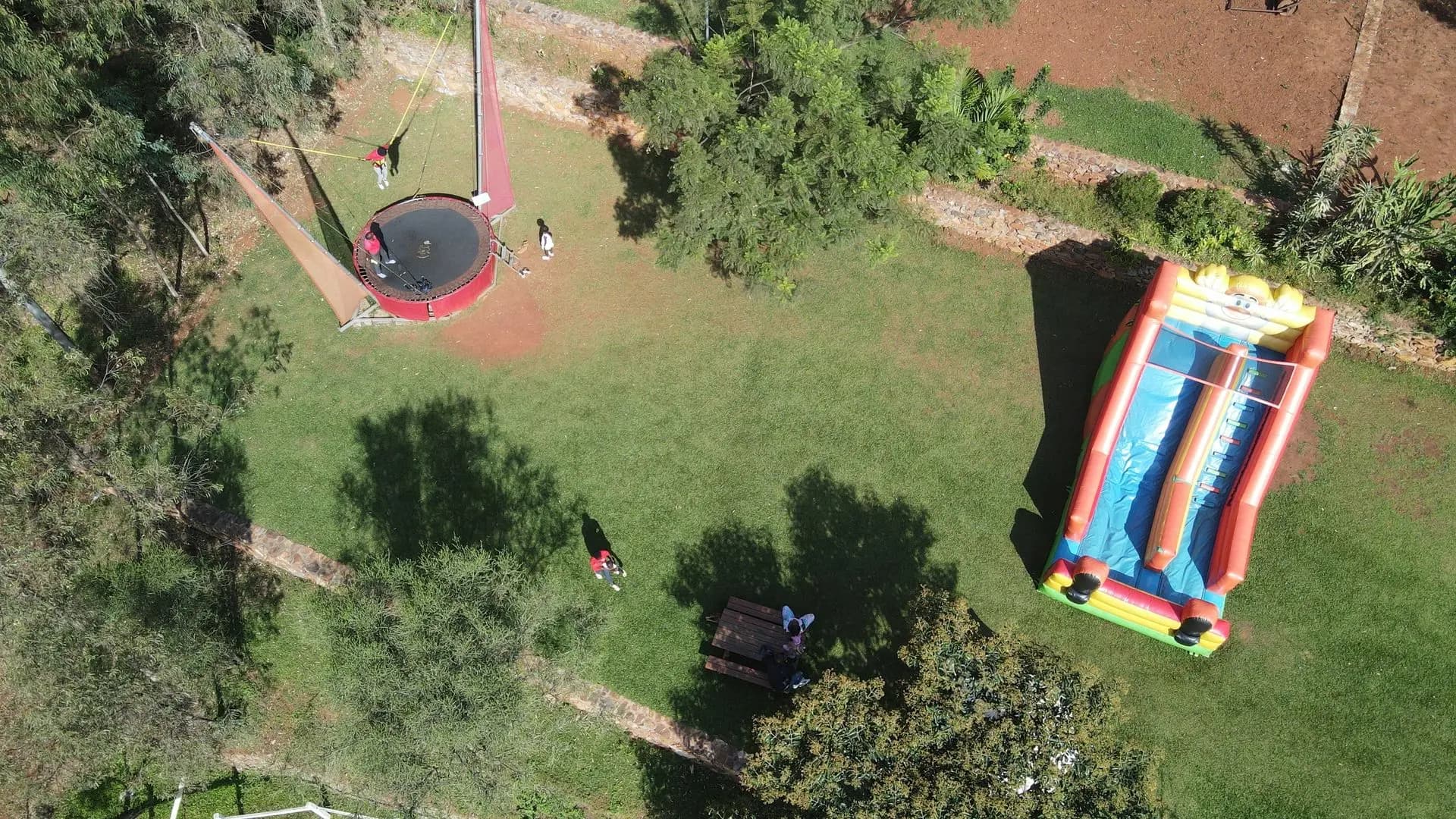 Aerial view over the Fazenda Sengha grounds, with the bungee trampoline, play lawn, and surrounding forest.