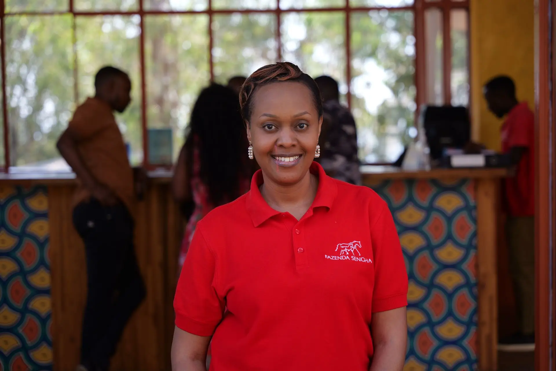 Dinah smiling at the Fazenda Sengha reception desk.